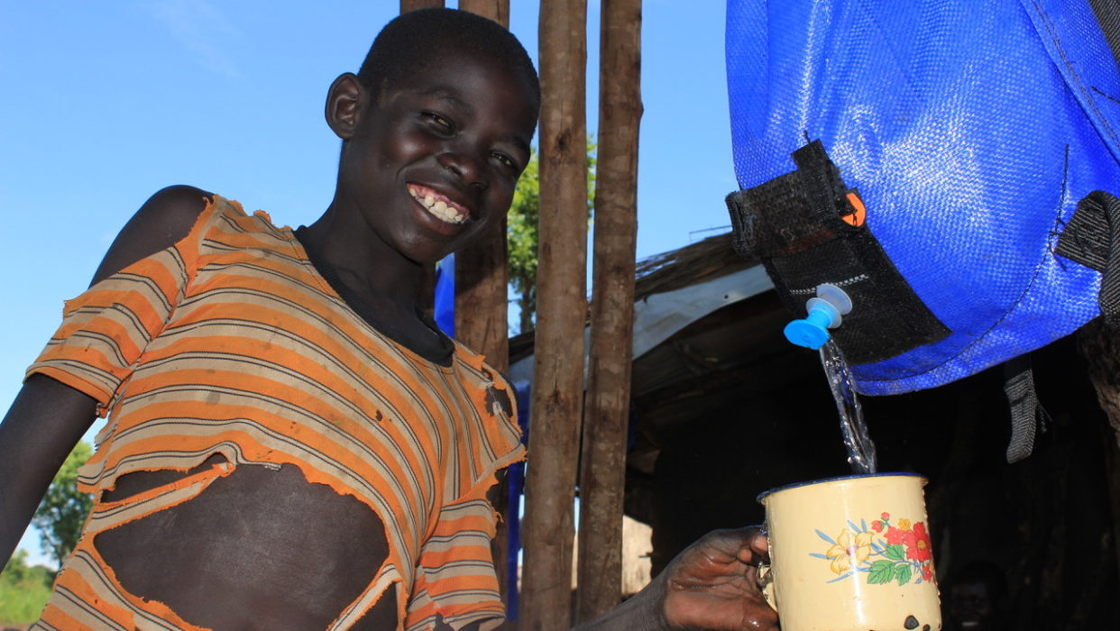 A South Sudanese refugee child getting clean water from a Pack H2O water backpack in Uganda