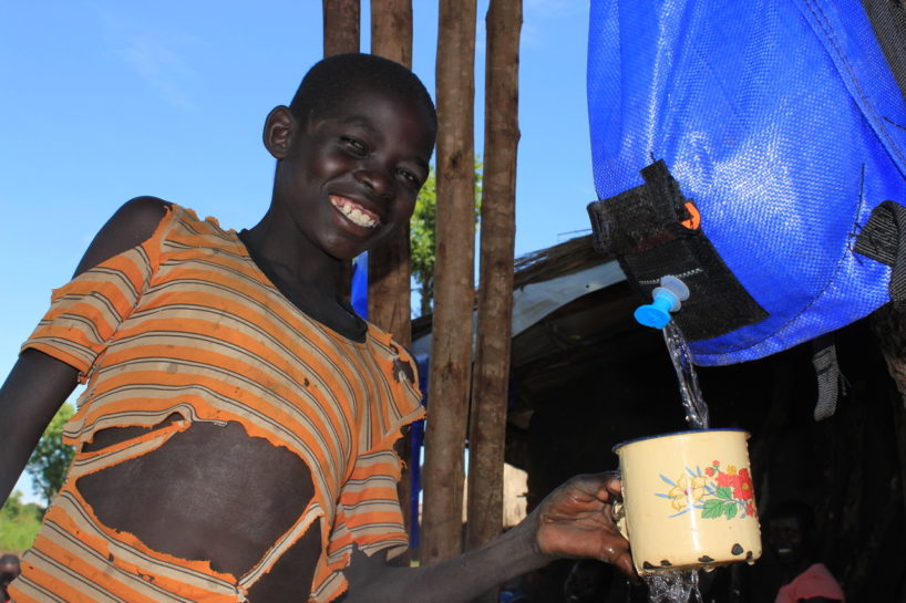 World Refugee Day - A South Sudanese refugee child getting clean water from a Pack H2O water backpack in Uganda World Refugee Day - A South Sudanese refugee child getting clean water from a Pack H2O water backpack in Uganda