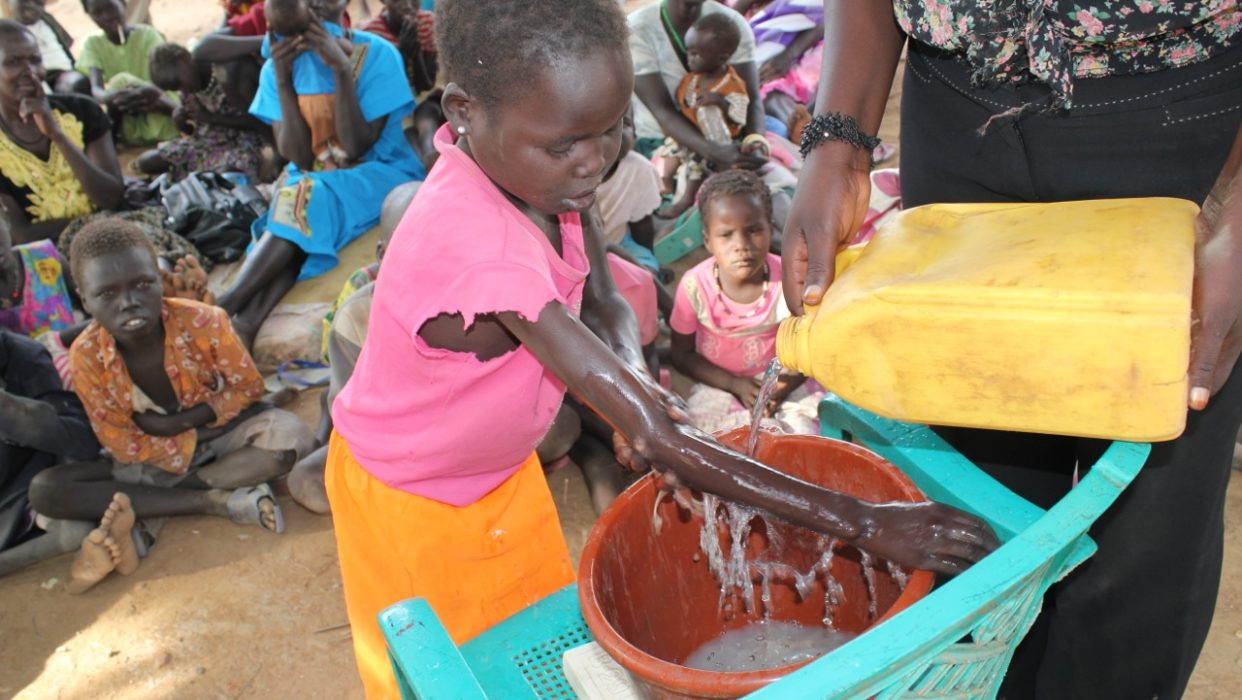 Drop in the Bucket hygiene and sanitation trainers teaching effective hand washing to South Sudanese refugee children.